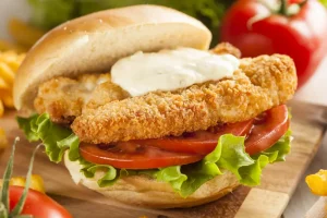 breaded fish burger, Chef Ed fish sandwich, crispy fish fillet, homemade tartar sauce, fish sandwich recipe, french fries, buttered buns, cod burger, panko fish, healthy fast food, athlete-friendly meal, tomato and lettuce burger, post workout sandwich, fish and chips sandwich, tartar sauce recipe, crispy fish sandwich, easy fish burger, gourmet fish burger, classic American lunch, comfort food recipe, chef ed kitchen, pan-fried fish, golden breaded fish, toasted sandwich buns, double fried fries, high protein sandwich, crispy seafood burger, dill pickles, red onion topping, chef ed burger recipe
