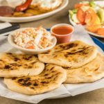 Keywords: pupusas, Salvadoran food, cheese pupusa, pupusas revueltas, masa harina recipe, Chef Ed, curtido slaw, salsa roja, Central American street food, grilled pupusa, gluten-free Latin food, Latin comfort food, pupusas de queso, pork pupusa, authentic pupusas, Loroco filling, homemade tortillas, Salvadoran cuisine, El Salvador recipes, Latin cheese dish, Latin American cuisine, fermented cabbage, healthy Latin meals, corn tortilla pupusa, stuffed masa dough, cheesy Latin snack, meat and cheese pupusa, pupusas tradition, Chef Ed pupusa recipe