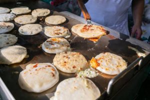 Keywords: pupusas, Salvadoran food, cheese pupusa, pupusas revueltas, masa harina recipe, Chef Ed, curtido slaw, salsa roja, Central American street food, grilled pupusa, gluten-free Latin food, Latin comfort food, pupusas de queso, pork pupusa, authentic pupusas, Loroco filling, homemade tortillas, Salvadoran cuisine, El Salvador recipes, Latin cheese dish, Latin American cuisine, fermented cabbage, healthy Latin meals, corn tortilla pupusa, stuffed masa dough, cheesy Latin snack, meat and cheese pupusa, pupusas tradition, Chef Ed pupusa recipe